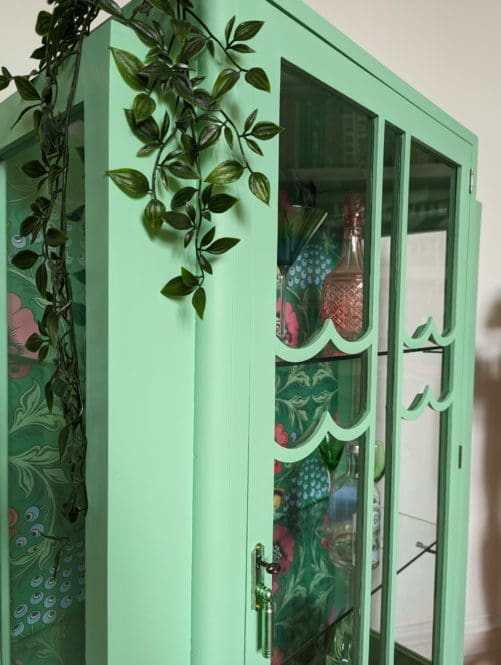 Scalloped glass panels to front of vintage green hand painted cabinet
