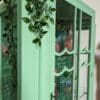 Scalloped glass panels to front of vintage green hand painted cabinet