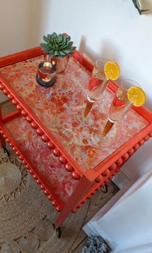 Orange gilded drinks trolley with marbled paper and bobbin details