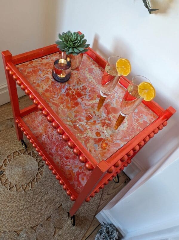 Orange gilded drinks trolley with marbled paper and bobbin details