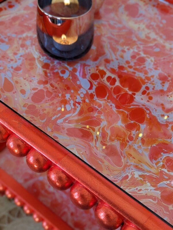 close up of orange marbled surface with orange gilded edge