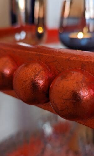 Close up of bobbin trim gilded in orange silver leaf