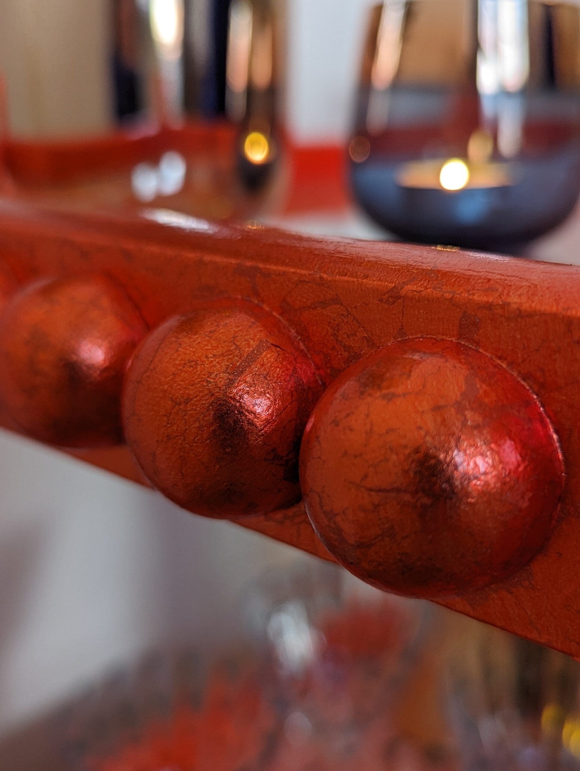 Close up of bobbin trim gilded in orange silver leaf