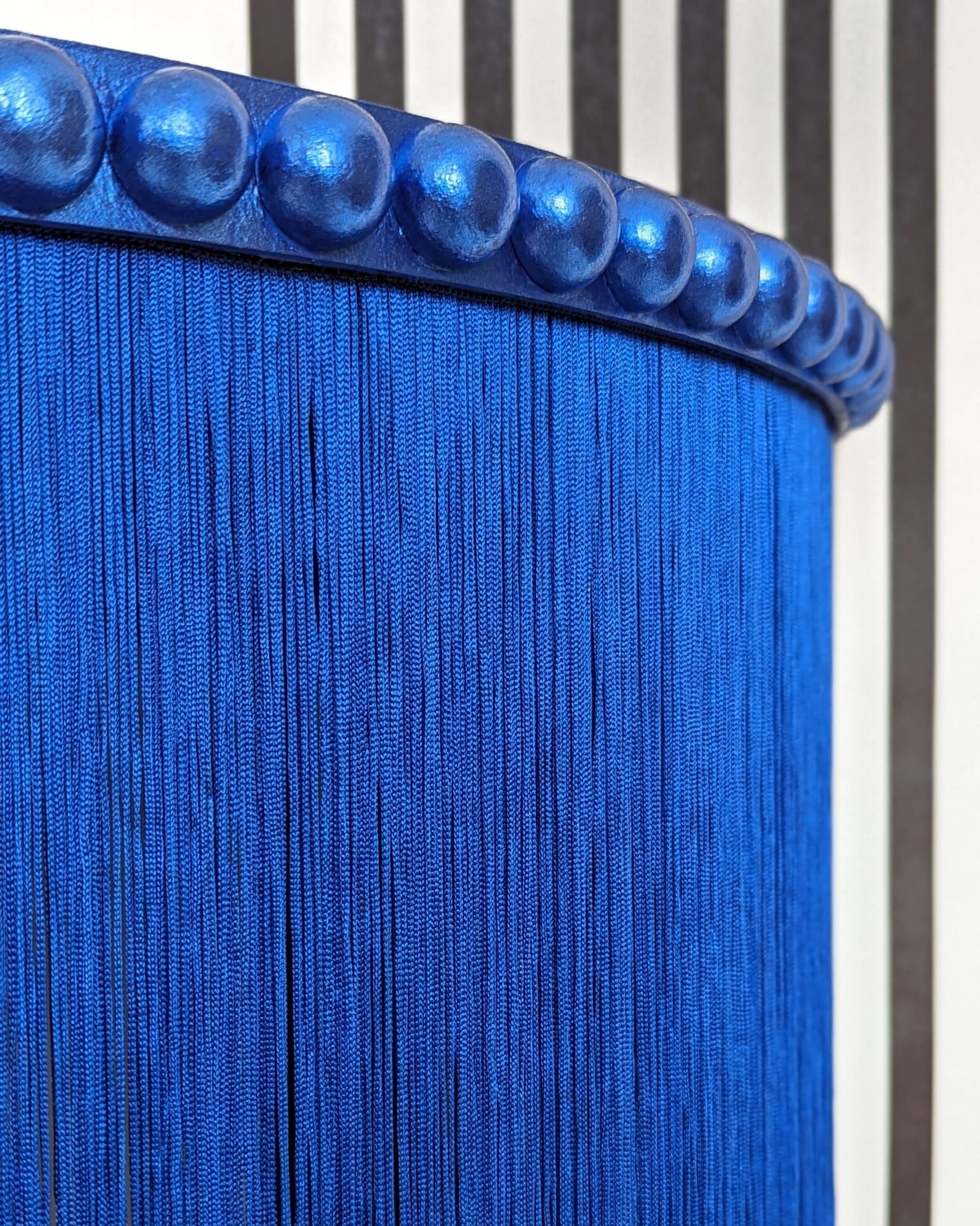 Close up of blue gilded bobbin trim and fringing