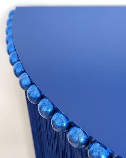 Blue console table top with close up of gilded bobbin trim