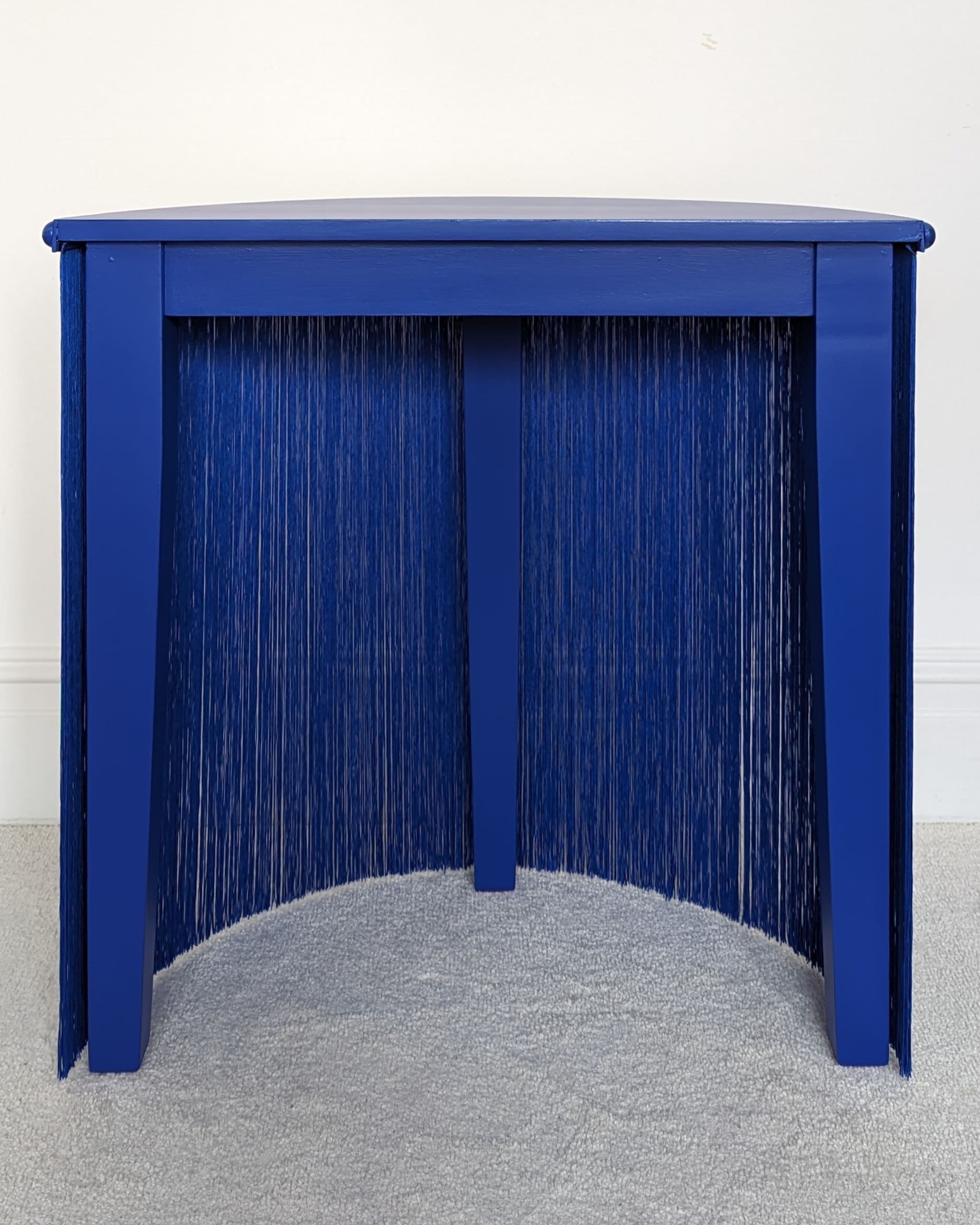 Blue fringed semi circle console table back view