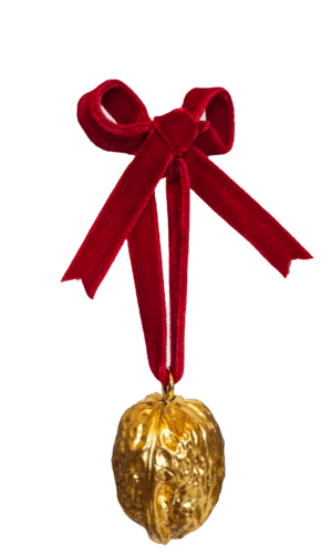 Gold walnut decoration with red velvet bow on a white background