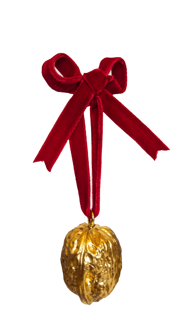 Gold walnut decoration with red velvet bow on a white background