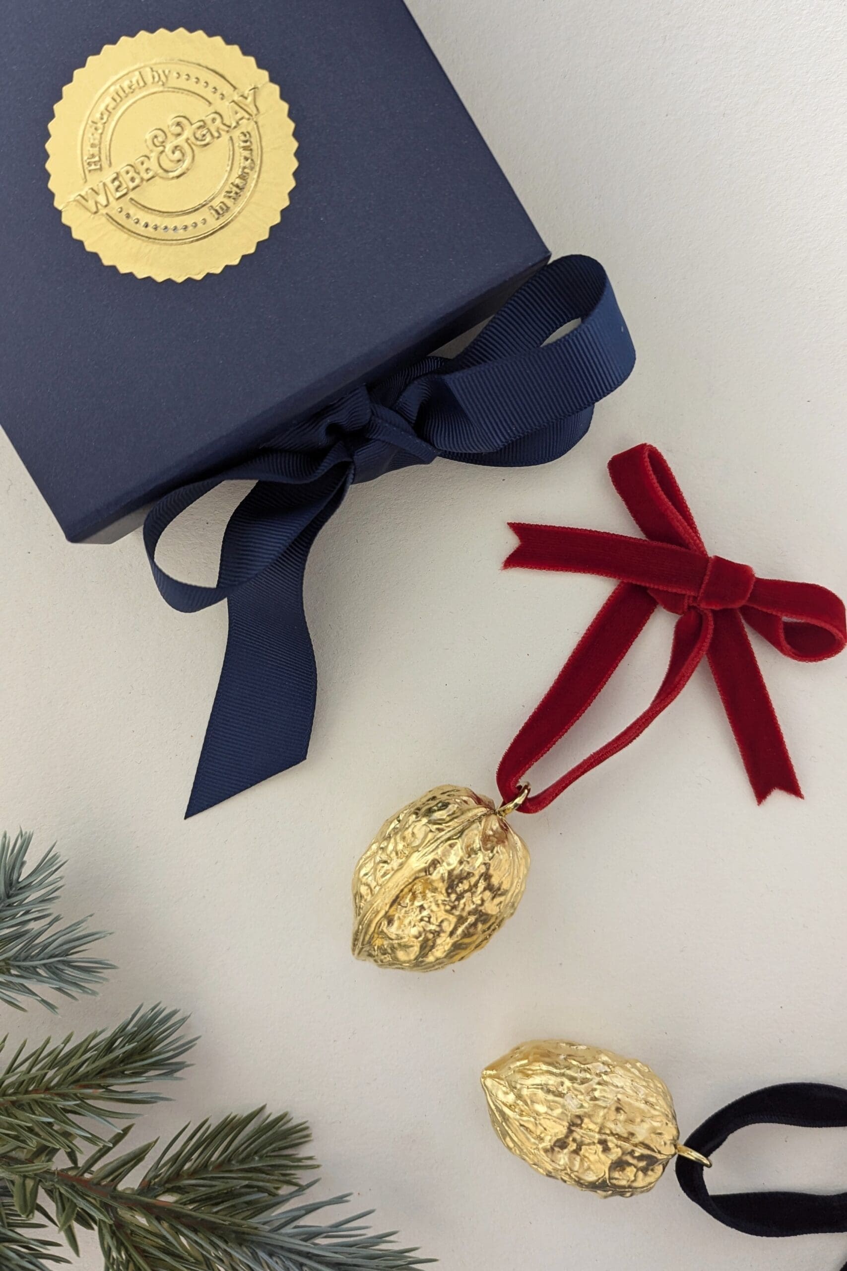 Gold walnut tee decorations with a navy gift box