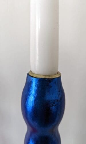 Top of artisan candlestick gilded in genuine red dyed silver leaf handcarfted from reclaimed table legs