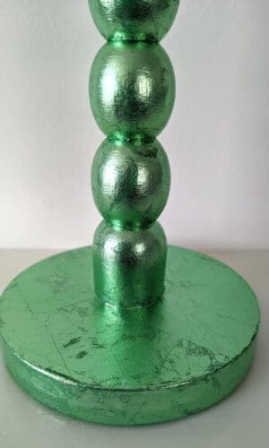 Close up of base of blue gilded bobbin candlestick showing soft metallic sheen and texture