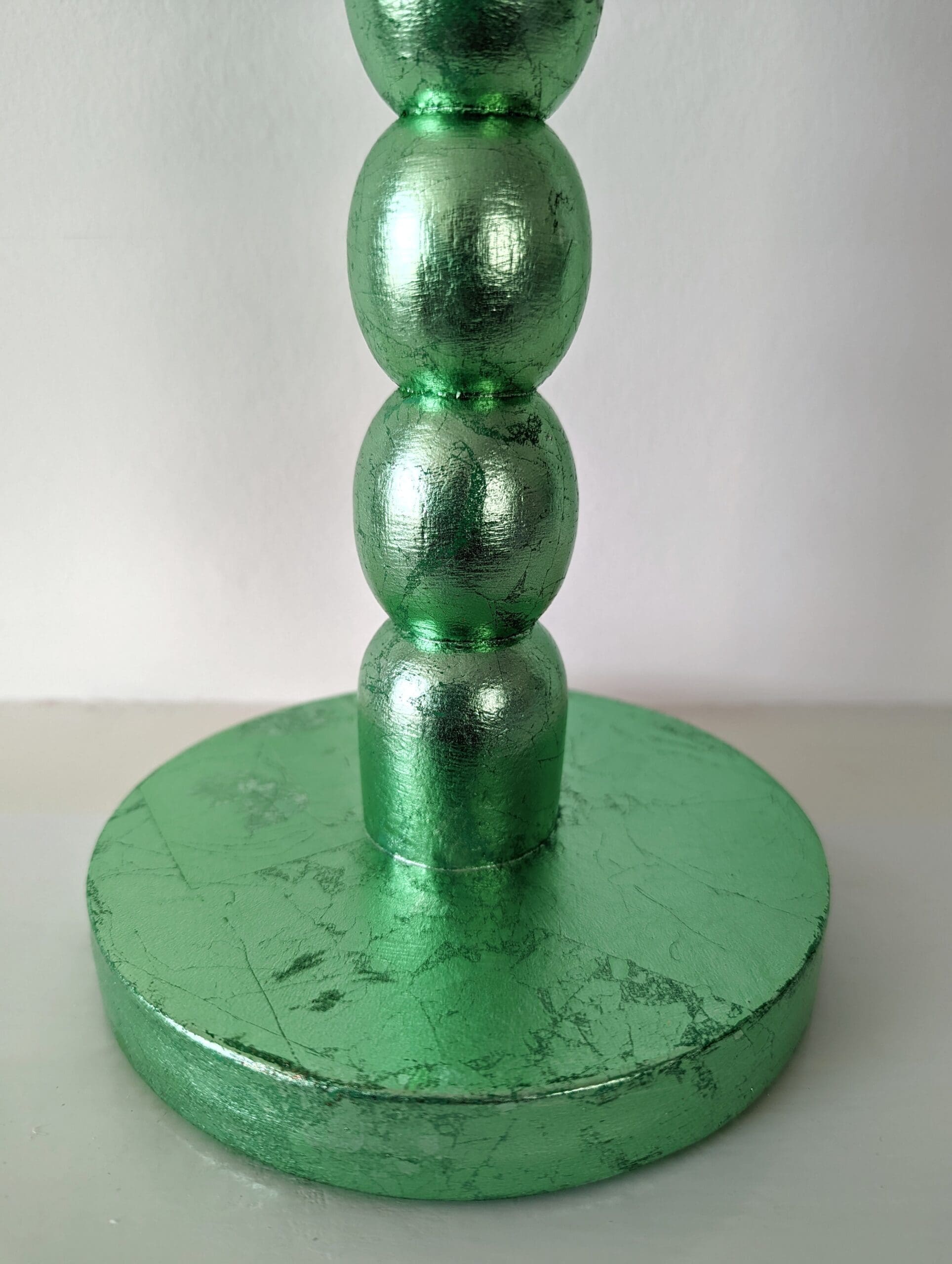 Close up of base of blue gilded bobbin candlestick showing soft metallic sheen and texture