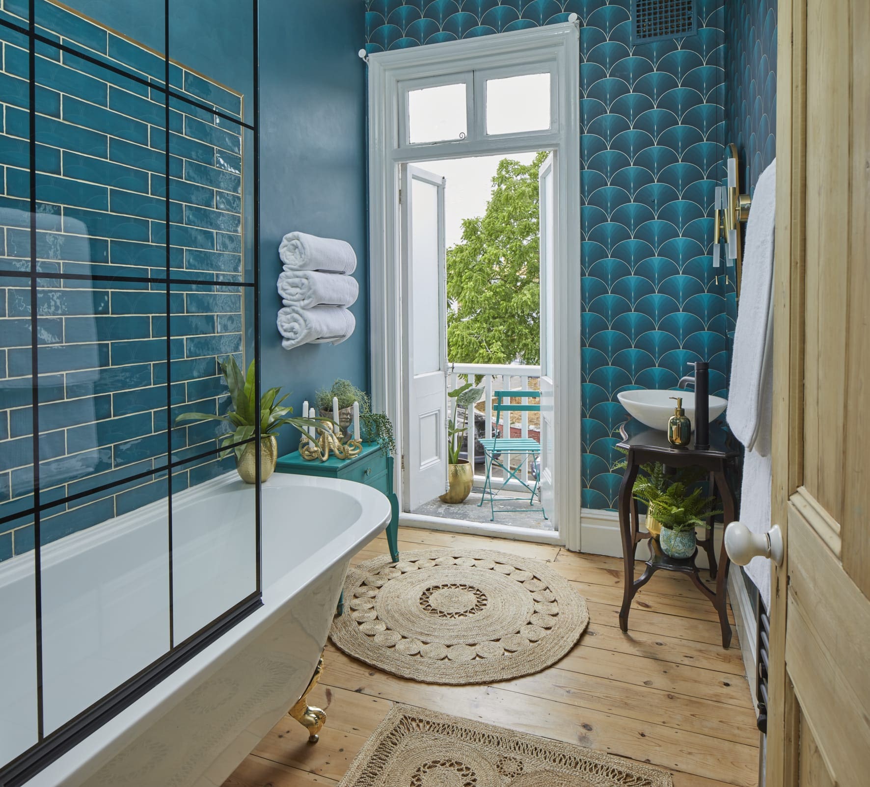 bathroom with turquoise wallpaper and freestanding bath