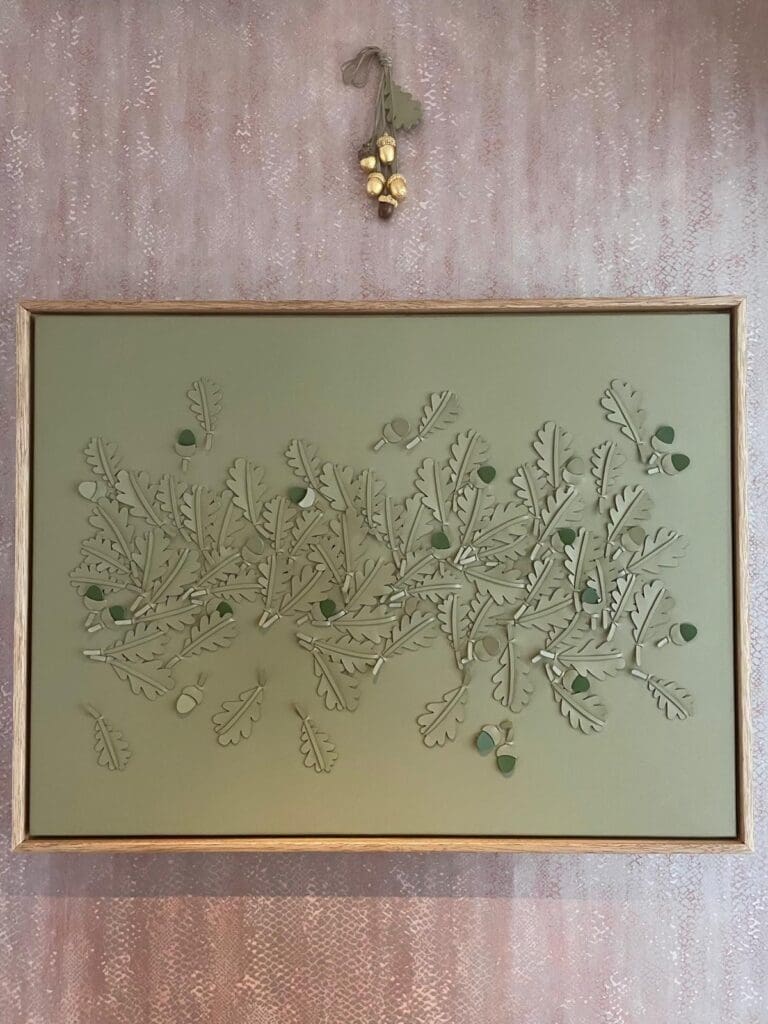 Haynes Interiors - Louise Heighes artwork and gilded acorns by Webb & Gray Green leather oakleaf artwork with cluster of gilded acrons hung above