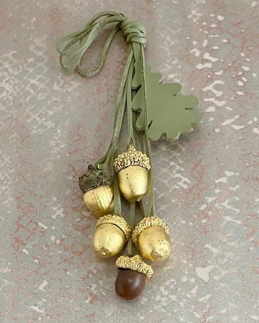 cluster of gilded acorns tied with green leather strips and green leather oak leaf