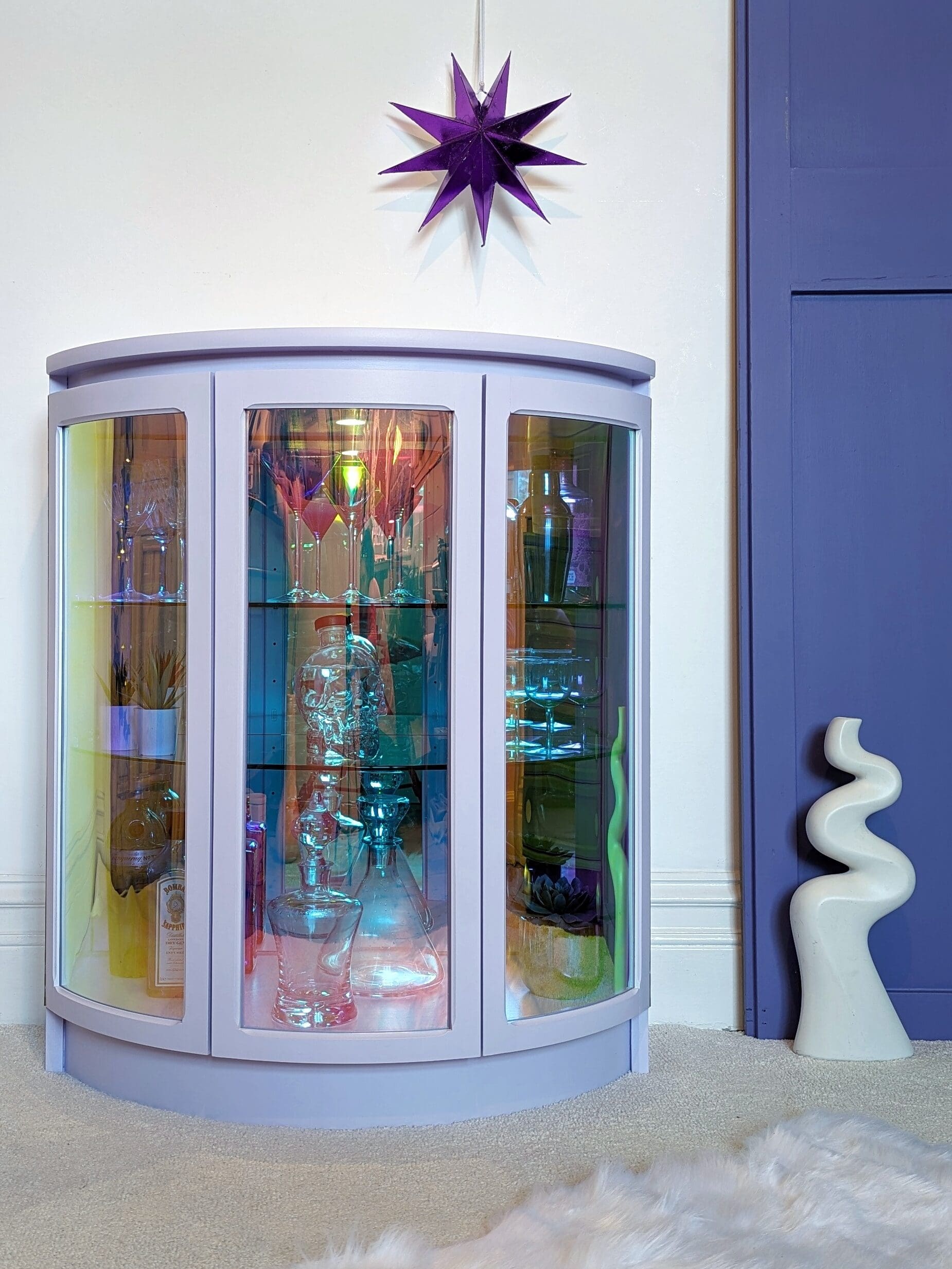 Lilac drinks cabinet with iridescent curved glass doors