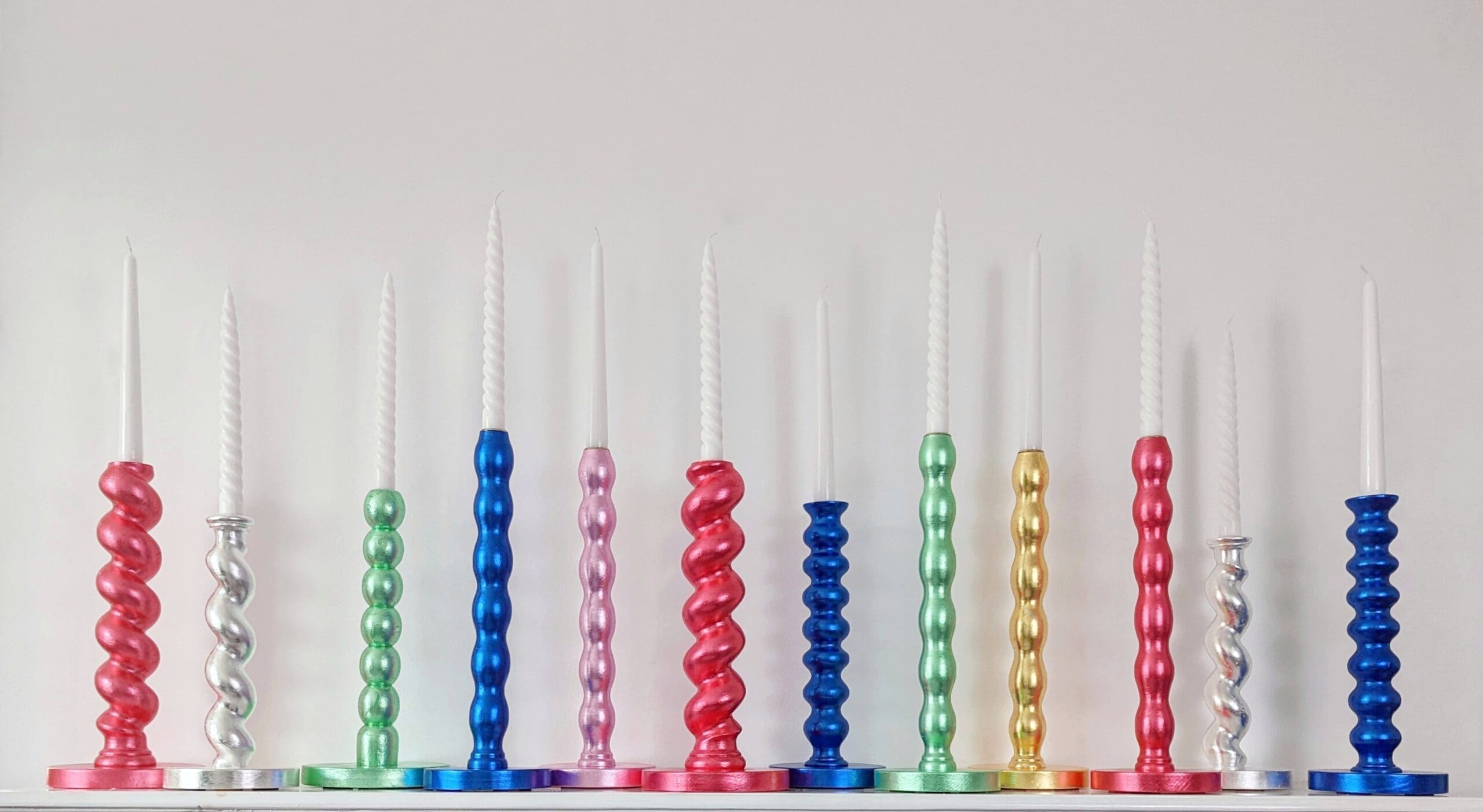 Multi-coloured gilded candlesticks made of reclaimed table legs