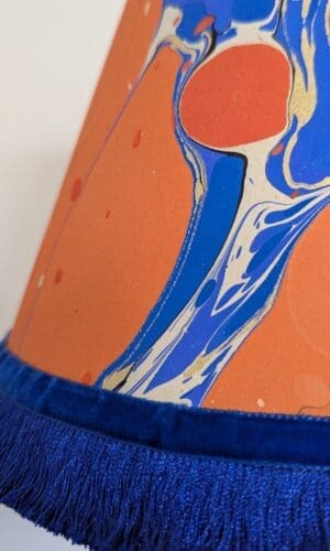 orange and blue marbled lampshade close up detail of royal blue silky fringing and velvet ribbob trim