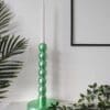 Metallic mint green bobbin candlesticks on mantlepiece with trailing plant