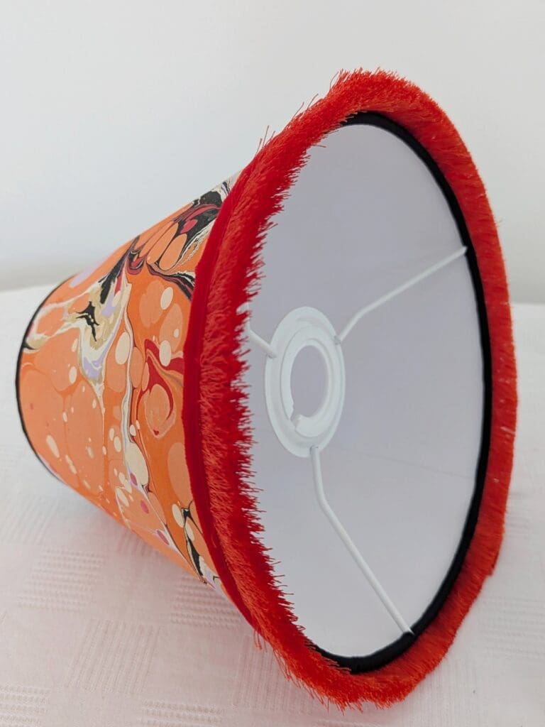 inside view of orange marbled paper lampshade showing sustainable white cardboard lining