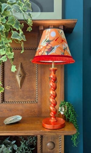 orange twist lamp with marbled lampshade on wooden mantelpiece