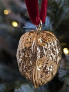 Gilded walnut hanging on red velvet ribbon on a Christmas tree