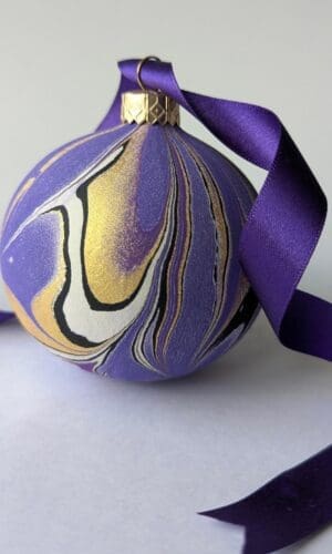 Purple and gold marbled bauble with trailing purple satine ribbon