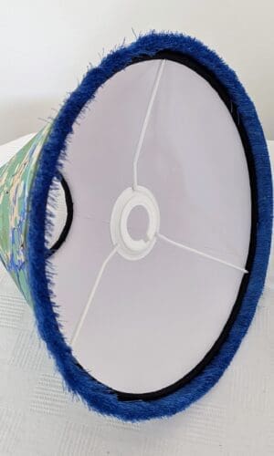 Inside view of blue and green marbled lampshade showing white cardboard interior