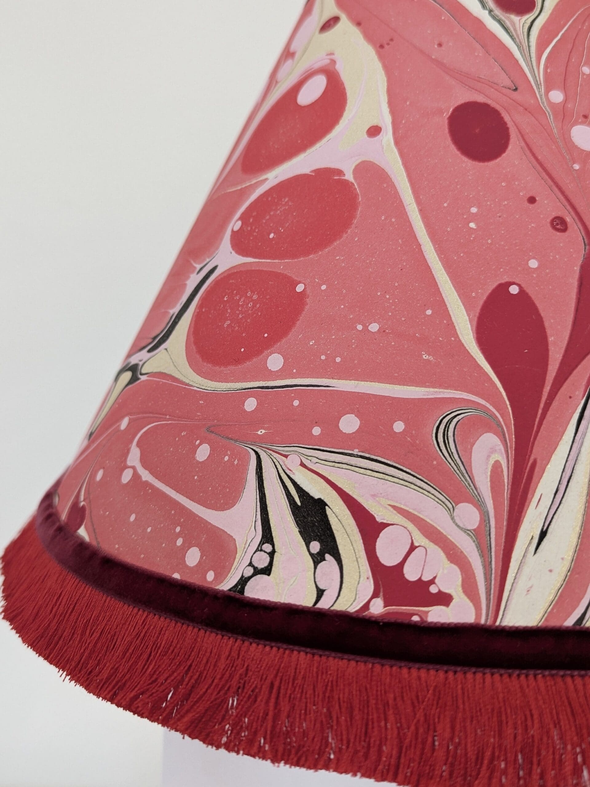 close up of handmade red and gold marbled paper lampshade