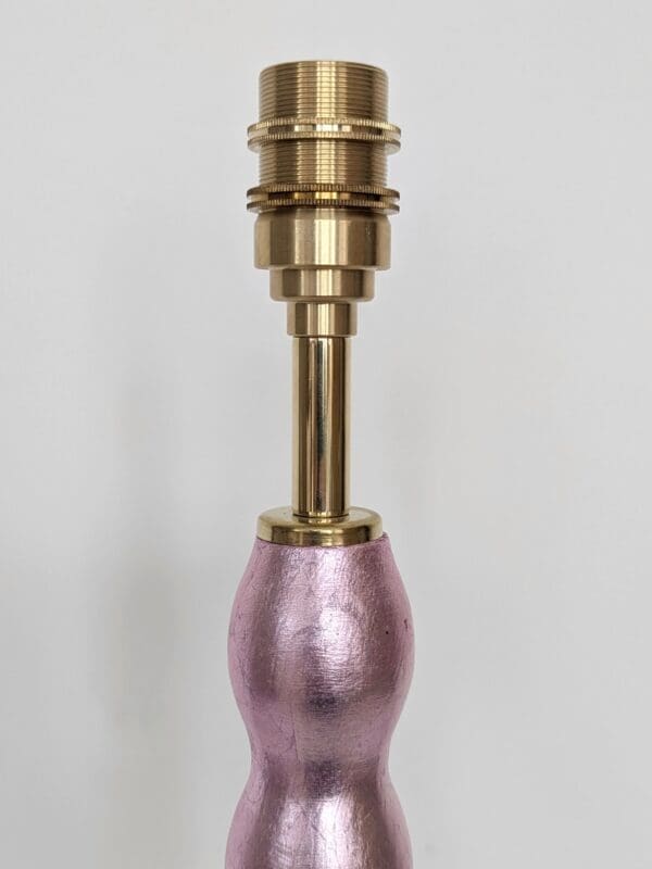 close up of brass bulb holder on pale pink gilded cordless lamp