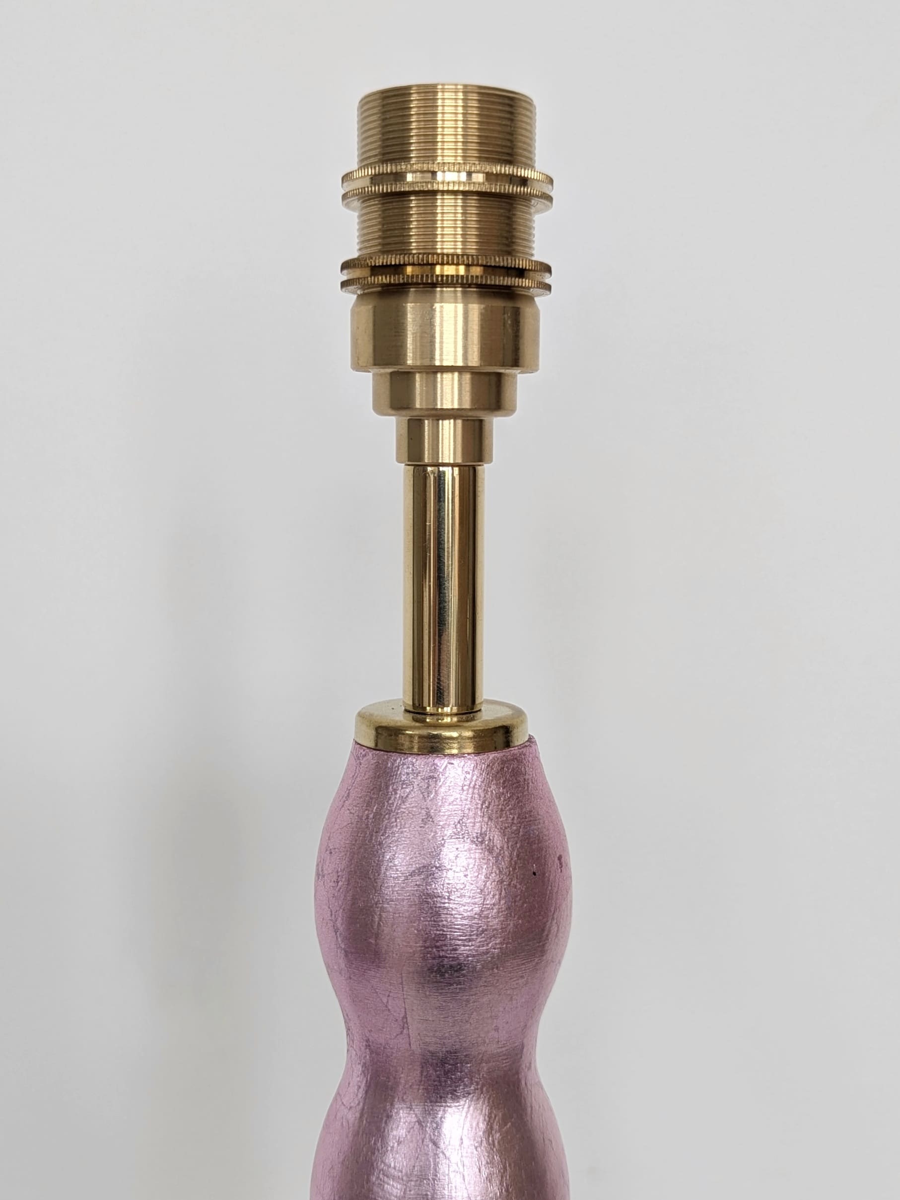 close up of brass bulb holder on pale pink gilded cordless lamp