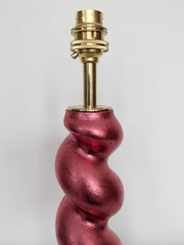 close up of top of gilded barleytwist red cordless lamp showing brass bulb holder