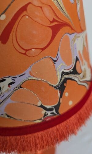 close up of orange, lilac, black and red marbled paper lampshade