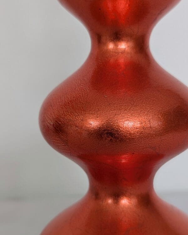 close up of orange curvy lamp showing the rich colour and texture of the orange dyed silver leaf finish