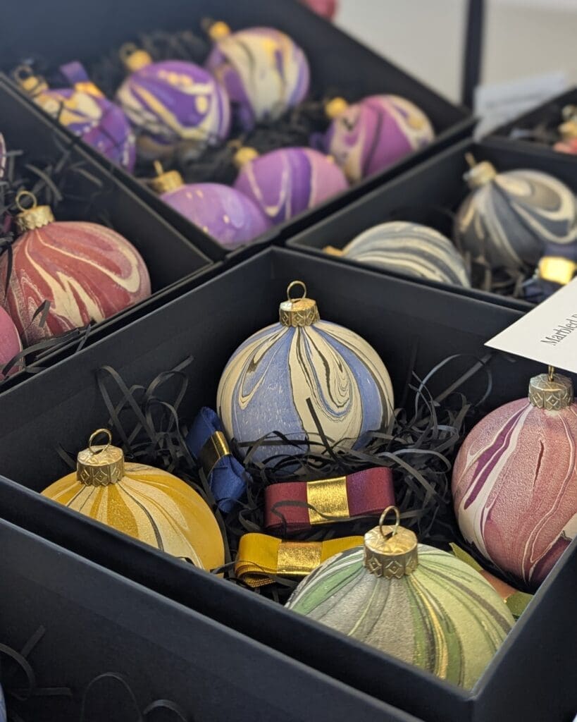 Handmade marbled Christmas baubles on display at a craft fair