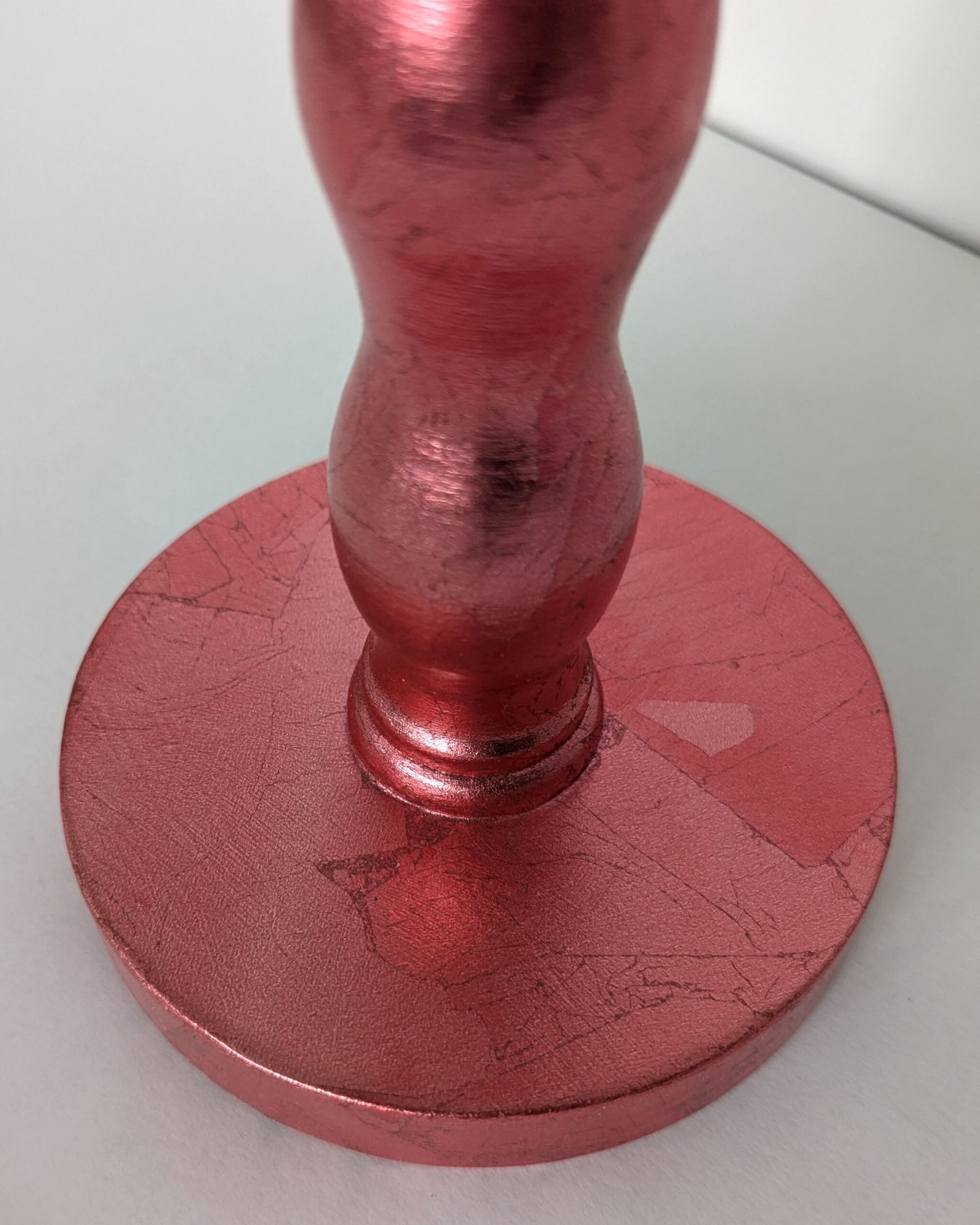 close up of red cordless lamp base showing texture and sheen of red dyed silver leaf finish