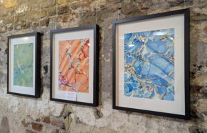 Framed marbled artworks in blue, orange and green colourways