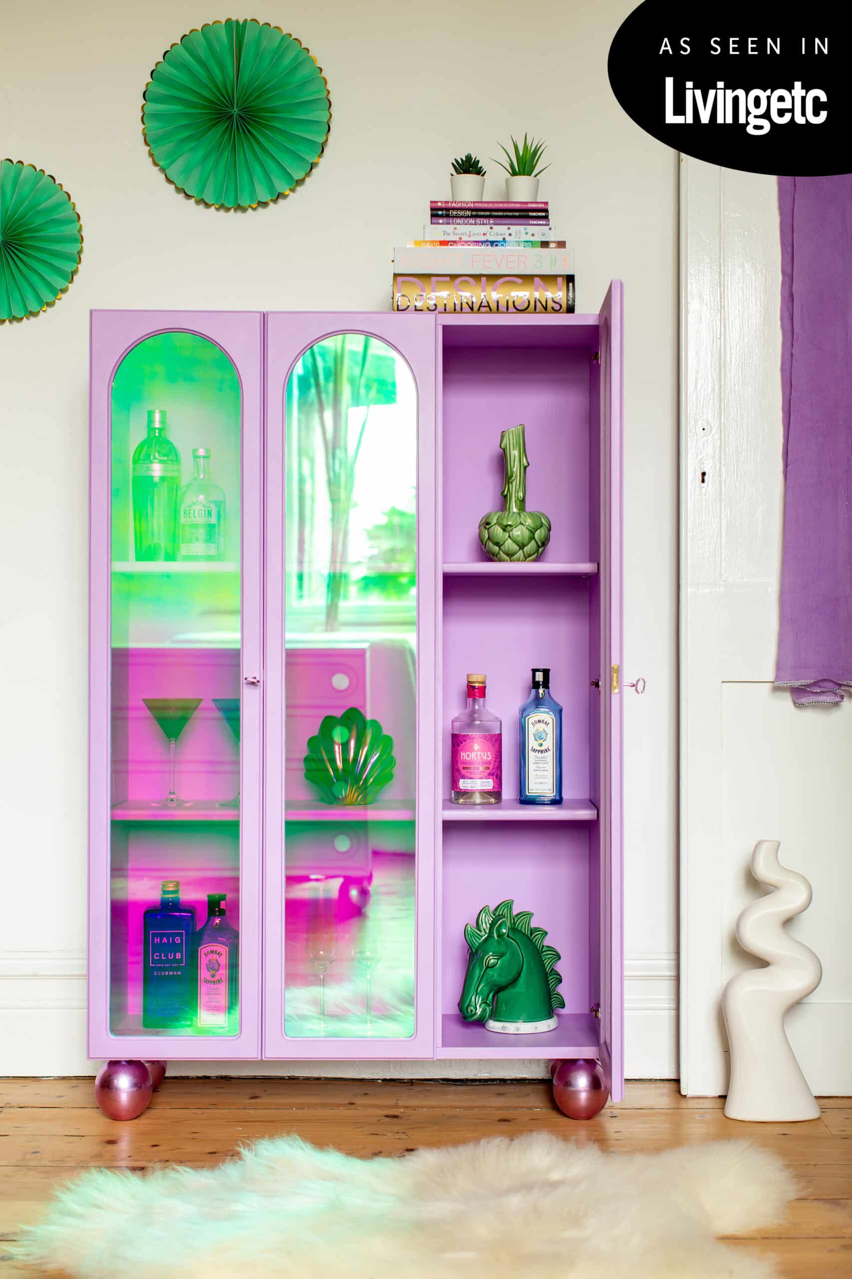 Pink display cabinet with iridescent glass and one door open.