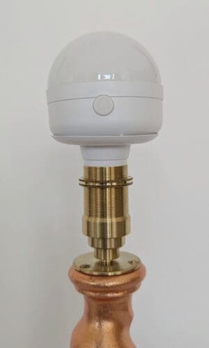 Top of peach cordless lamp with brass bulb holder and rechargeable LED bulb
