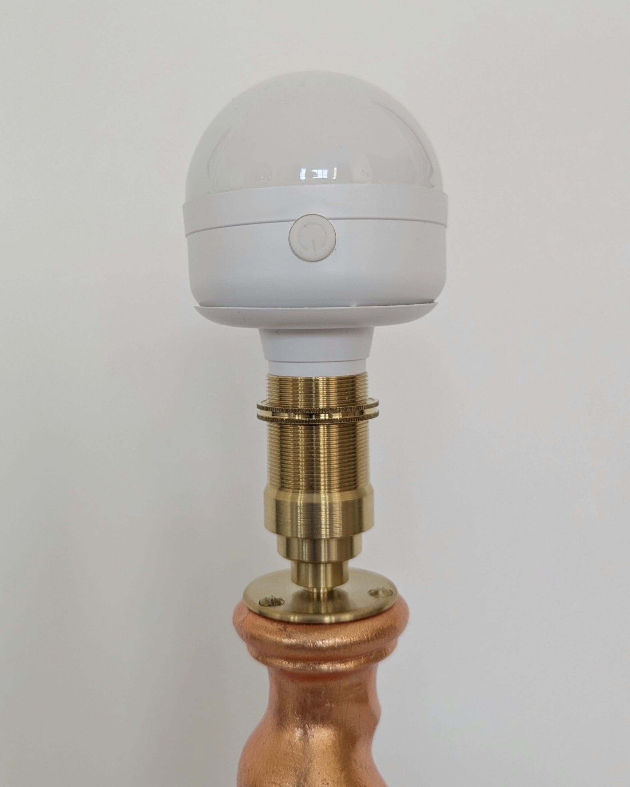 Top of peach cordless lamp with brass bulb holder and rechargeable LED bulb