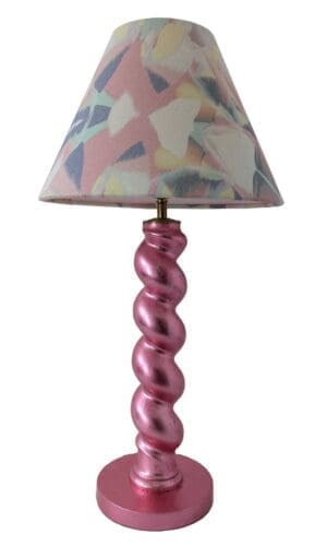 Cutout image of metallic pink twist table lamp with pastel geometric lampshade