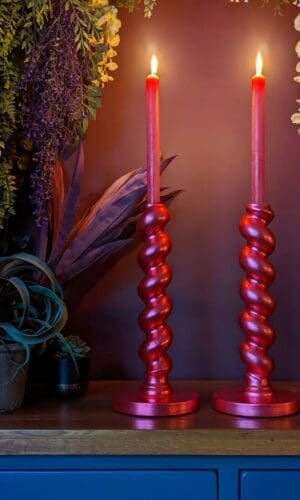 gilded twisted red candlesticks against dark background