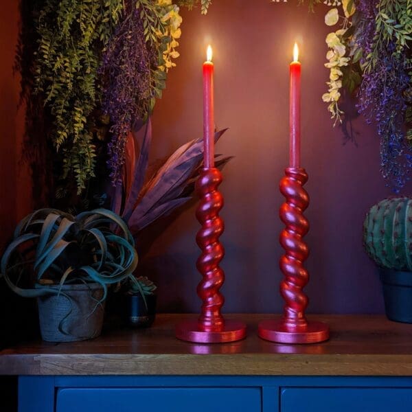 gilded twisted red candlesticks against dark background