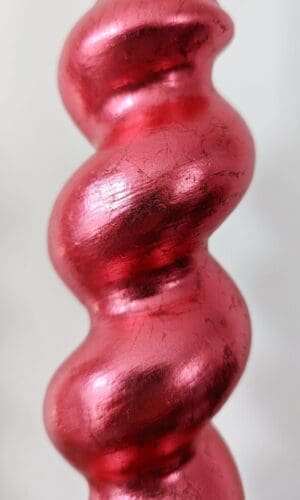 Close up of red gilded barleytwist candlesticks showing soft metallic sheen and texture