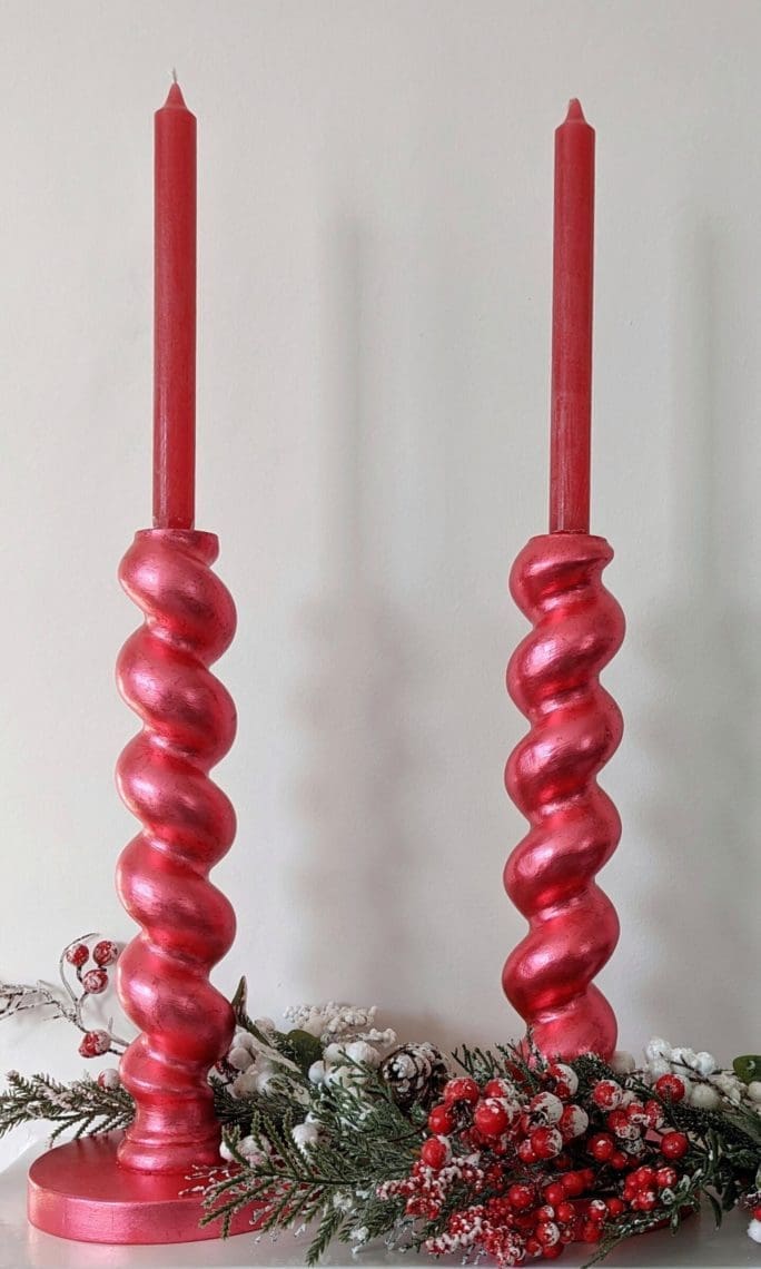 Metallic chunky, barleytwist candlesticks with red candles and snowy Christmas garland