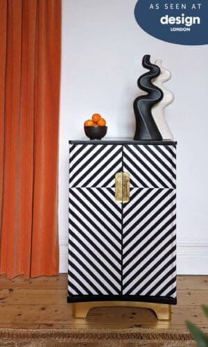 Front view of black and white striped cabinet with gold plinth and handles