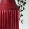 Close up of red gilded fluted detail on red plant stand