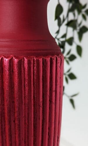 Close up of red gilded fluted detail on red plant stand