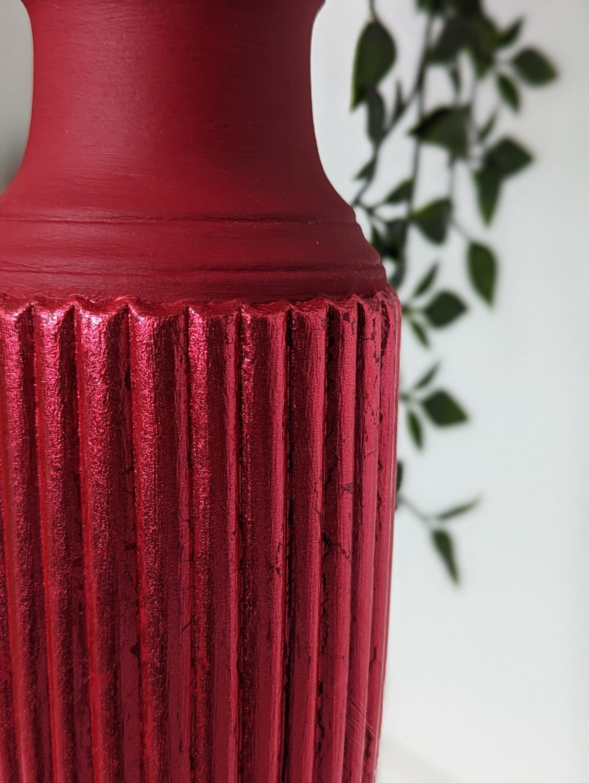 Close up of red gilded fluted detail on red plant stand
