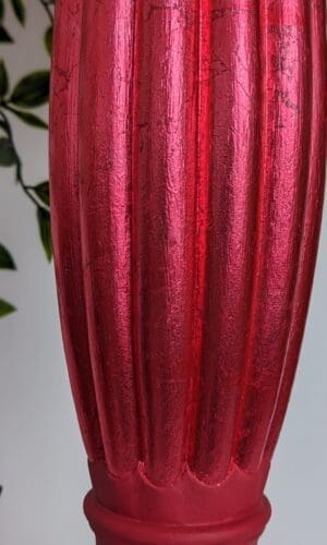 Close up of red gilded fluted detail on red plant stand